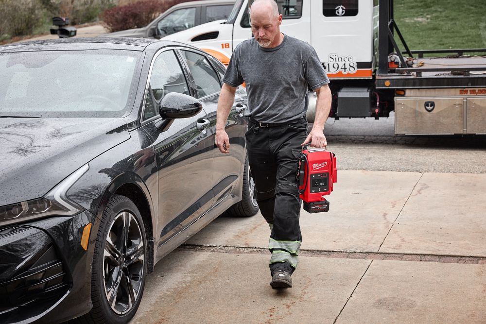 Man walking with Milwaukee Jump Starter